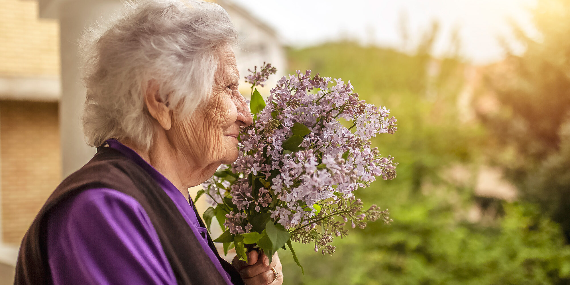 Senior woman smelling lilacs Ten Signs of Dementia